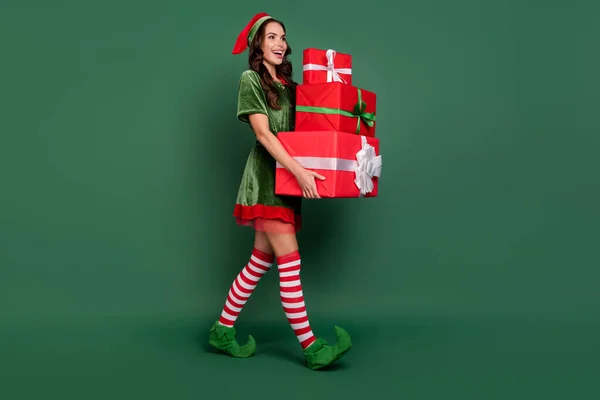 Foto lateral de perfil de tamanho completo da menina feliz sorriso positivo ir entregar caixa de presente ano novo isolado sobre fundo de cor verde — Fotografia de Stock