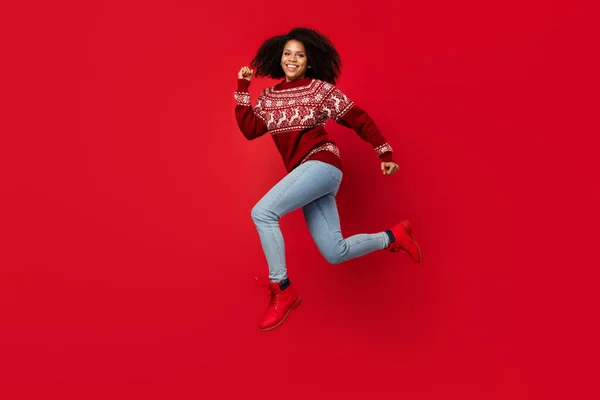 フル丈ボディサイズ写真女性笑顔ジャンプ実行中のセーター孤立した明るい赤の色の背景 — ストック写真