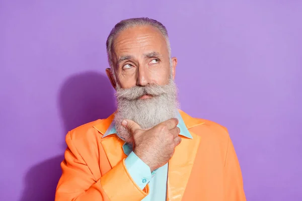 Photo of dreamy minded old man look empty space brainstorm face hand chin isolated on purple color background — Stock Photo, Image