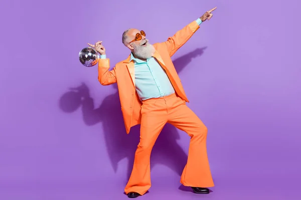 Plná délka fotografie starého pozitivního muže držet disco koule bod vypadat prázdný prostor izolované na fialové barvy pozadí — Stock fotografie