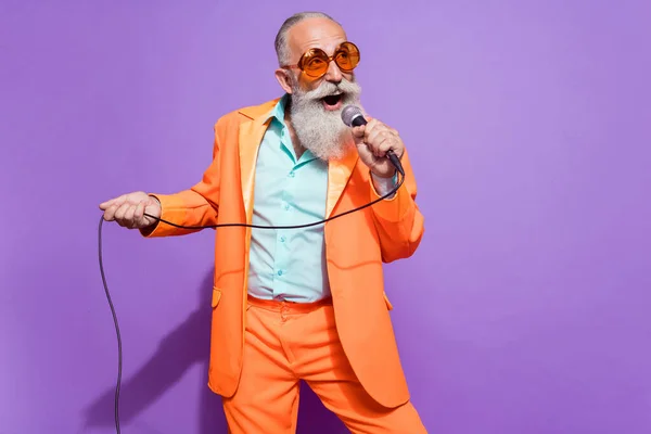 Karaoke yapan yaşlı hayalperest adamın fotoğrafı. Güneş gözlüğü takıyor. Mor arka planda izole edilmiş boş bir alan. — Stok fotoğraf