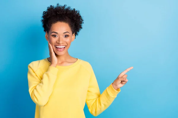 Foto retrato rizado mujer sonriendo sorprendido mostrando copyspace aislado pastel azul color fondo — Foto de Stock