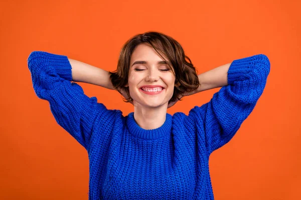 Retrato de menina sonhadora alegre atraente usando pulôver de inverno descansando isolado sobre fundo de cor laranja brilhante — Fotografia de Stock