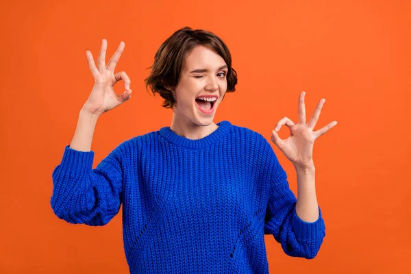 Foto portrét žena usmívá ukazující v pořádku gesta mrkání izolované zářivé oranžové barvy pozadí copyspace — Stock fotografie