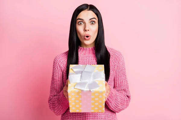 파스텔 핑크 색 배경에 고립된 선물 상자를 들고 있는 놀란 소녀의 사진 — 스톡 사진