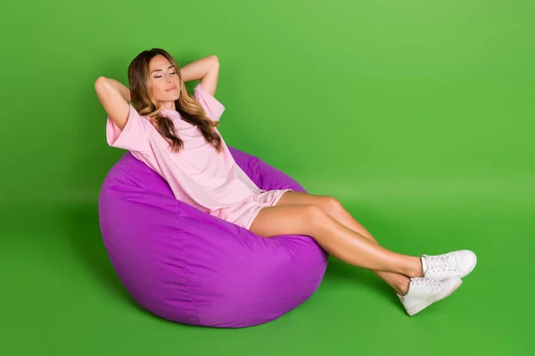 Corpo inteiro foto de positivo feliz sonhador mulher sentar feijão sono desfrutar fim de semana isolado no fundo cor verde — Fotografia de Stock