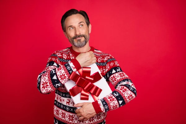 Foto ritratto uomo in maglione dall'aspetto sognante spazio vuoto tenere presente durante le vacanze invernali isolato vibrante colore rosso sfondo — Foto Stock