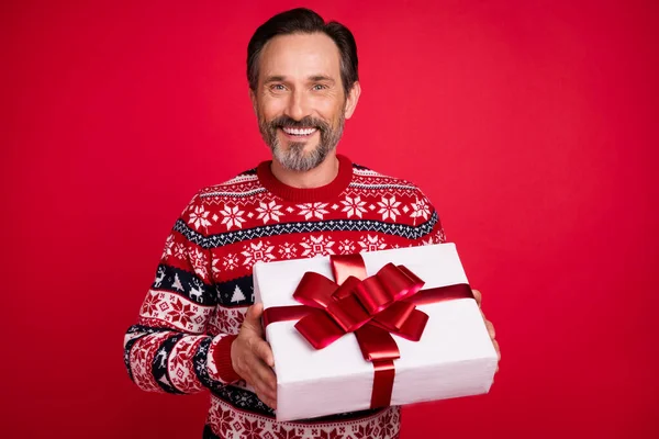 Foto retrato hombre en suéter sonriente mantener presente la caja en suéter aislado de color rojo brillante fondo —  Fotos de Stock