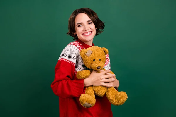 Portrait of attractive cheerful girl holding hugging old bear december day isolated over green color background — Stock Photo, Image