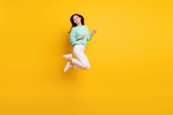 긍정적 인 행복 한 여성의 전신 사진 손가락빈 우주 점프노란 색 배경에서 분리 — 스톡 사진