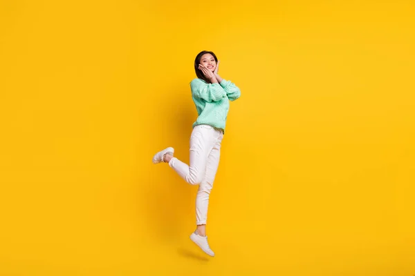 Foto em tamanho completo de mulher bonita bonita saltar ar sorriso segurar as mãos rosto bochechas isoladas no fundo de cor amarela — Fotografia de Stock