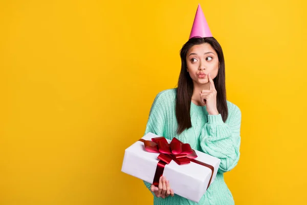 Düşünceli genç bir kadının fotoğrafı boş görünüyor. Doğum günü hediyesini sarı arka planda izole et. — Stok fotoğraf