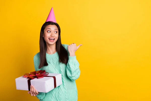 Foto van positieve gelukkige jonge vrouw wijzen vinger kijken lege ruimte aanwezig houden geïsoleerd op gele kleur achtergrond — Stockfoto