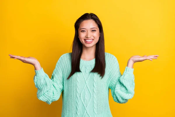 Foto de engraçado encantador jovem senhora usar camisola turquesa comparar dois espaço vazio sorrindo isolado cor amarela fundo — Fotografia de Stock