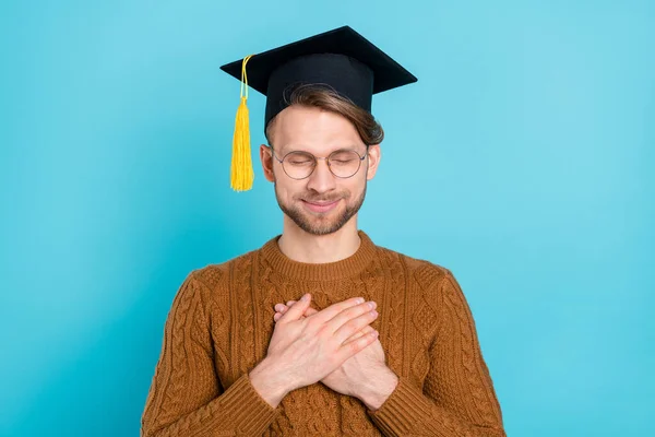 Foto di tranquillo giovane uomo tenere le mani petto indossare occhiali cappello giurare isolato su sfondo di colore blu — Foto Stock