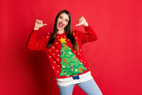 Foto di allegra bruna felice orgogliosa giovane donna indossare jeans punta dita se stessa Natale isolato su sfondo di colore rosso — Foto Stock