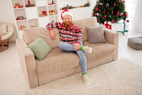 Full length body size photo bearded man chilling at home sitting on sofa near decorated xmas tree — Stock Photo, Image