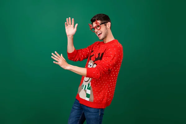 Profilseite Foto von jungen Mann glücklich positives Lächeln Spaß haben Tanz X-mas Party Brille Hörner isoliert über grüne Farbe Hintergrund — Stockfoto