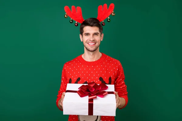 Foto retrato homem em camisola de malha vermelha mantendo xmas presente caixa sorrindo isolado cor verde fundo — Fotografia de Stock