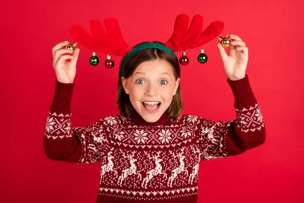 Фото молодої дівчини щаслива позитивна посмішка вражена збудженими руками торкаються іграшкових рогів оленів, ізольованих на фоні червоного кольору — стокове фото