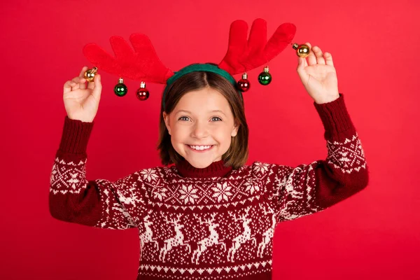 Фото молодої дівчини щаслива позитивна посмішка носити оленячі кульки різдвяний дух ізольовані на фоні червоного кольору — стокове фото