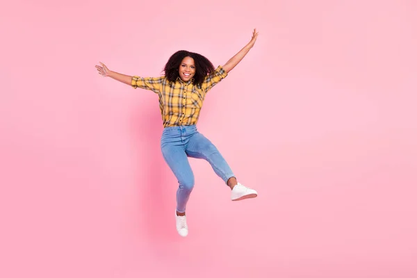 Foto de alegre positivo enérgico senhora salto levantar as mãos desgaste xadrez camisa jeans sapatos isolado cor rosa fundo — Fotografia de Stock