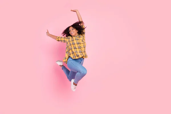 Foto van mooie blij geïnspireerde sportieve dame springen ga dragen geruite shirt jeans sneakers geïsoleerde roze kleur achtergrond — Stockfoto