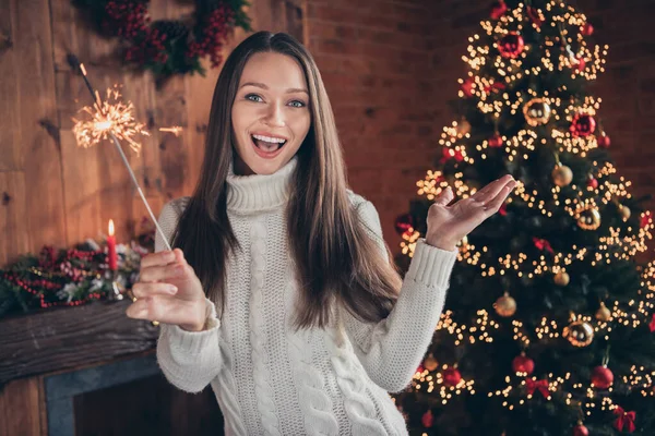 Photo de brillante adorable jeune femme porter pull blanc souriant tenant feu d'artifice bâton intérieur maison maison chambre — Photo