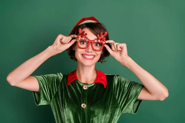 Foto de complicado encantador jovem senhora elfo traje headwear chifres óculos sorrindo isolado cor verde fundo — Fotografia de Stock