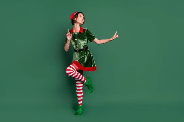 Comprimento total tamanho do corpo vista de menina alegre atraente elfo dançando se divertindo descansando isolado sobre fundo de cor verde — Fotografia de Stock