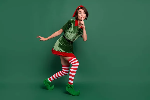 Full längd kroppsstorlek syn på attraktiva mystiska rolig flicka nisse visar shh tecken isolerad över grön färg bakgrund — Stockfoto