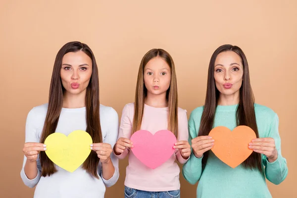 Porträtt av tre attraktiva flickor som håller kort hjärta pout läppar amour isolerad över beige pastell färg bakgrund — Stockfoto