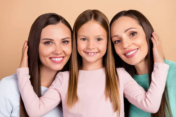 Porträtt av tre attraktiva glada anbud söt tillgiven flickor bindning krama isolerad över beige pastell färg bakgrund — Stockfoto