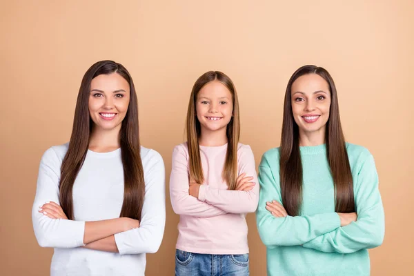 Portrét tří atraktivních veselých dívek složené zbraně tým podporu izolované přes béžové pastelové barvy pozadí — Stock fotografie