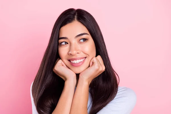 Foto ritratto di ragazza con capelli castani sorridente felice cercando spazio vuoto isolato su sfondo di colore rosa pastello — Foto Stock