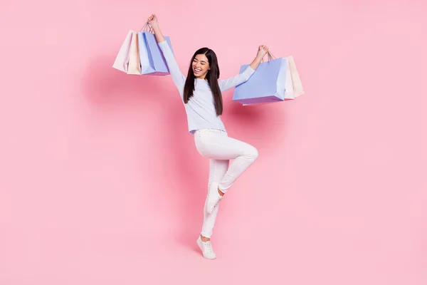 Volledige lengte lichaam grootte uitzicht van mooie dunne vrolijke meisje holding tassen dansen plezier geïsoleerd over roze pastel kleur achtergrond — Stockfoto