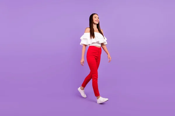 Profiel foto van positieve zorgeloze charmante dame genieten lopen dragen witte blouse broek geïsoleerde violette kleur achtergrond — Stockfoto