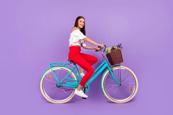 Foto de la señora alegre paseo bicicleta primavera fin de semana desgaste blusa blanca pantalones zapatos aislados color púrpura fondo —  Fotos de Stock