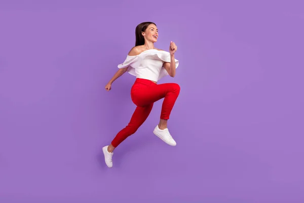 Foto de perfil de sporty enérgico señora salto correr desgaste blusa blanca pantalones calzado aislado color púrpura fondo — Foto de Stock