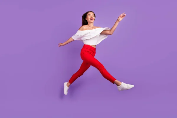 Foto de feliz sonhador desportivo senhora salto executar desfrutar de voo desgaste branco blusa isolado roxo cor fundo — Fotografia de Stock