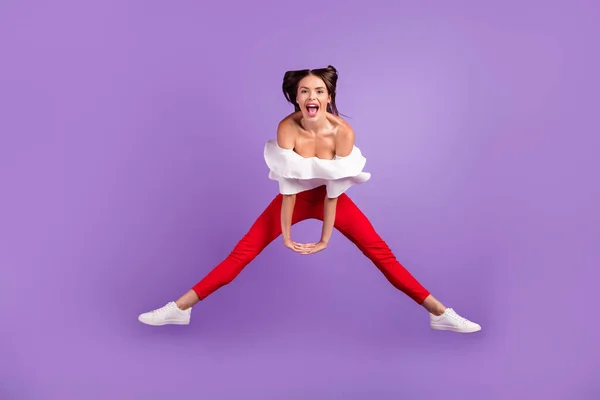 Foto di pazzo negligente signora salto tenere per mano urlare indossare camicetta bianca pantaloni scarpe da ginnastica isolato colore viola sfondo — Foto Stock