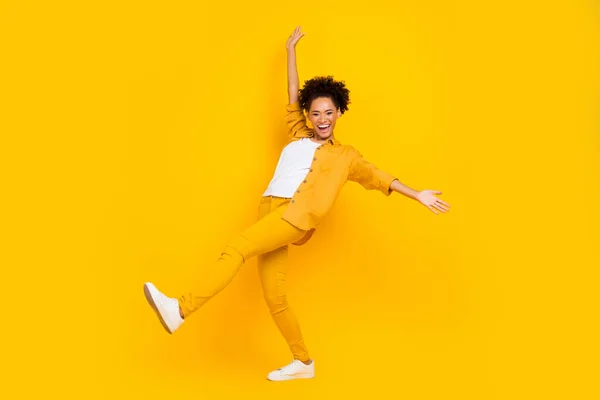 Perfil de corpo inteiro foto lateral da jovem menina negra alegre se divertir brincalhão ir andar isolado sobre fundo de cor amarela — Fotografia de Stock