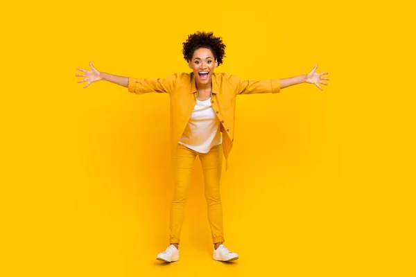 Teljes hosszúságú fotó fiatal vidám afro lány nyitott kéz szívesen ölelés vendégszerető elszigetelt sárga szín háttér — Stock Fotó