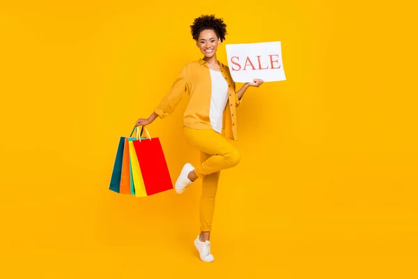 Volledige lengte body size foto vrouw houden tassen papieren kaart in winkelcentrum geïsoleerde levendige gele kleur achtergrond — Stockfoto