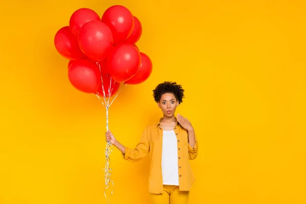 Фото молодой черной девушки удивлен шокирован многие шары накачать день рождения сюрприз изолированы на желтом фоне цвета — стоковое фото