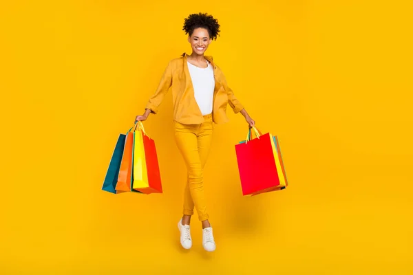 Tam boy vücut boy fotoğraf kadın alışveriş merkezinde çanta ile atlama izole sarı renkli arkaplan — Stok fotoğraf