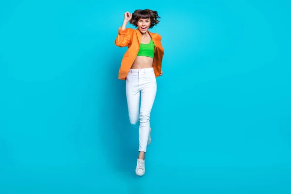 Full body photo of cheerful positive woman jump up air enjoy run you weekend isolated on blue color background — Stock Photo, Image