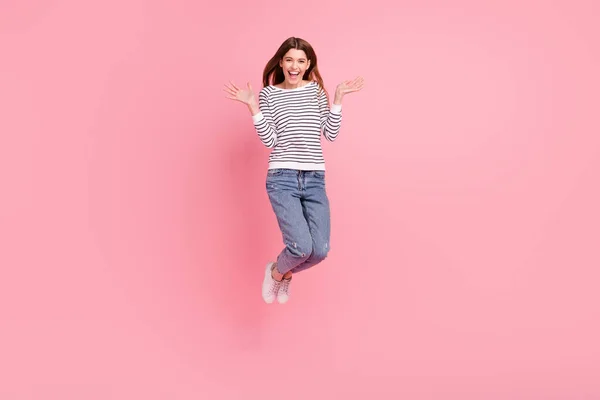 フル長いボディサイズビューの魅力的な明るいですラッキー女の子ジャンプ喜び絶縁上ピンクパステルカラー背景 — ストック写真