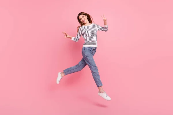 Tamanho do corpo de comprimento total vista de menina alegre atraente pulando mostrando v-sinal indo isolado sobre cor pastel rosa fundo — Fotografia de Stock