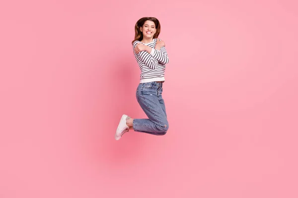 분홍색 파스텔 색 배경 위로 자신을 고립시키며 뛰어오르는 매력적 인 소녀의 전체 몸길이 사진 — 스톡 사진